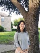 Xuesong Shao standing by a tree