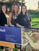 Your advising team standing behind a sign for sproul hall