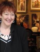 a woman smiling and standing in front of a wall of photos