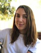 A woman with long brown hair wearing a white shirt