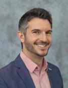 A photo of a man against a gray background.