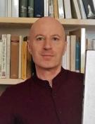 A man in front of a bookshelf.