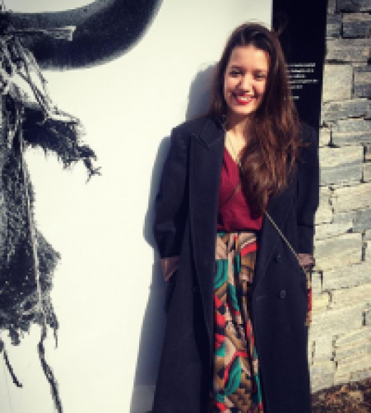 A picture of Jihan Shaarawi, standing and smiling at the viewer