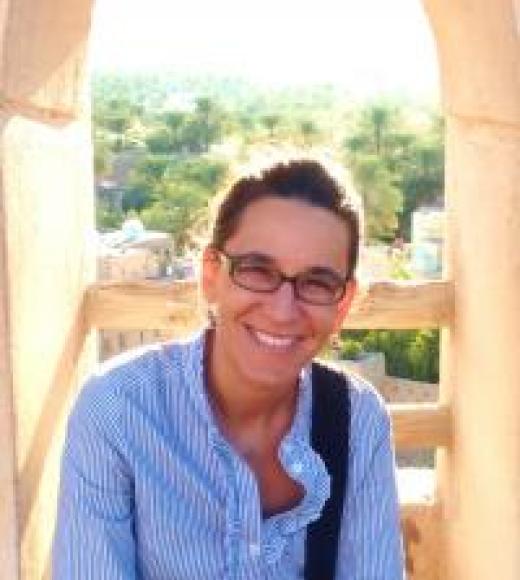 A picture of Professor Motlagh with a blue buttoned up shirt with the sleeves rolled up and a backpack over one shoulder.
