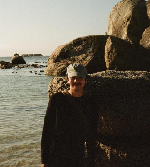 A person in a black shirt standing on the beach