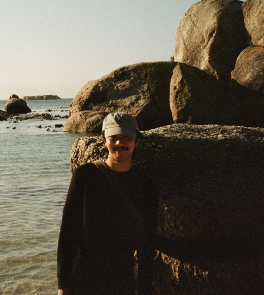 A person in a black shirt standing on the beach
