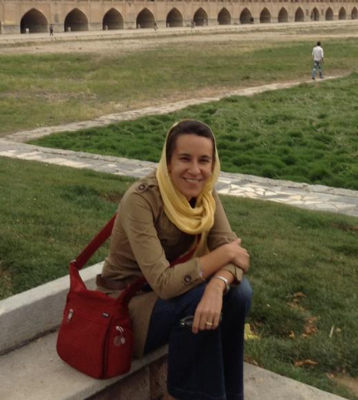 Professor Amy Motlagh seated outside with a head covering