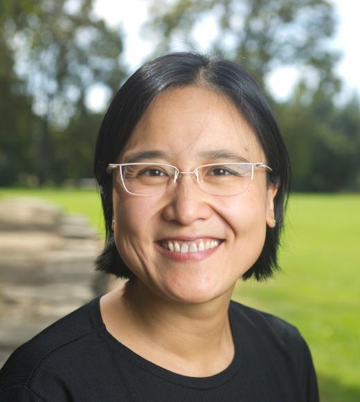 Woman in glasses standing in front of a grassy field