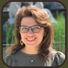 a photo of Leyla Tajir, a woman with long brown hair and glasses.