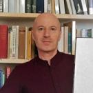 A man in front of a bookshelf.