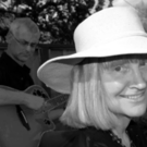 Woman in a hat with guitarist in the background