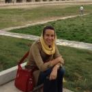 Professor Amy Motlagh seated outside with a head covering